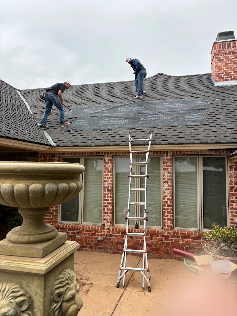 Roof-Tech crew repairing asphalt shingles on a residential roof